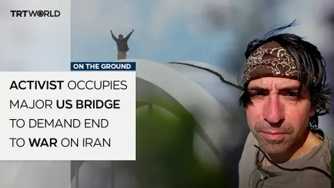 Anti-War Activist Perches on Major US Bridge in Protest Against Iran Conflict